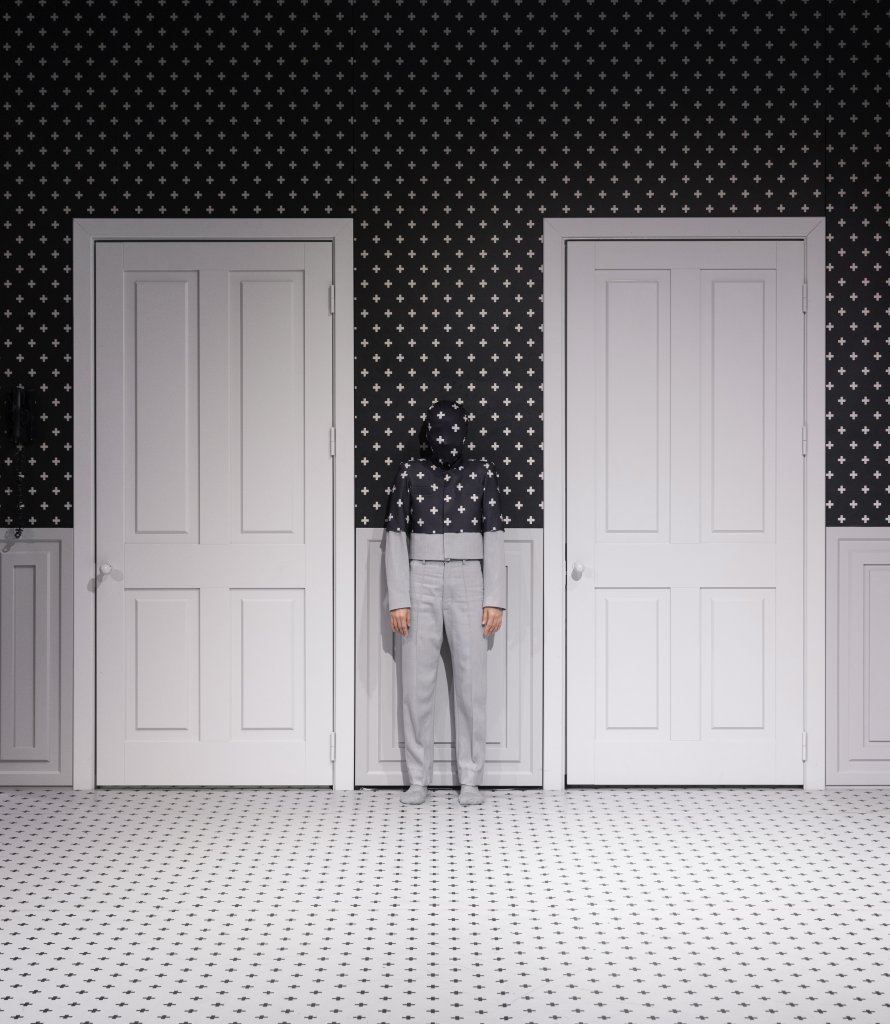 One dancer on stage, blending into the monochrome stage design